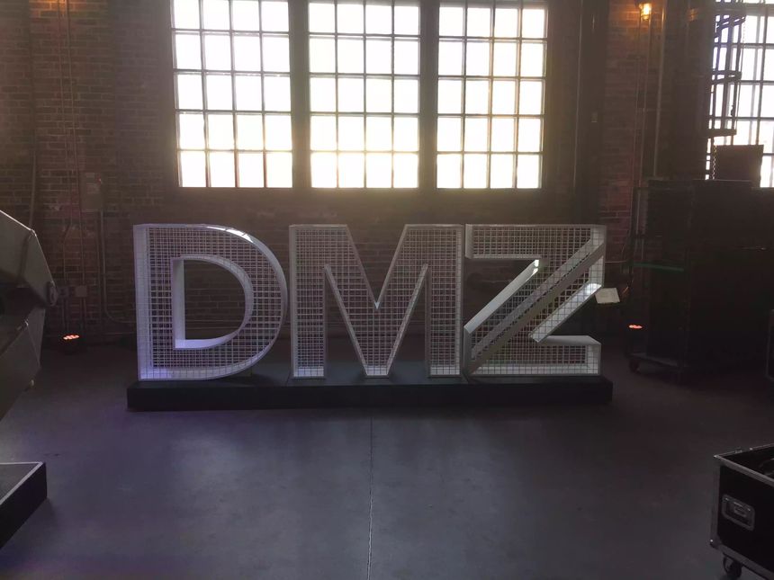 Custom large-format illuminated metal letterforms with welded mesh detailing, built for an event installation.