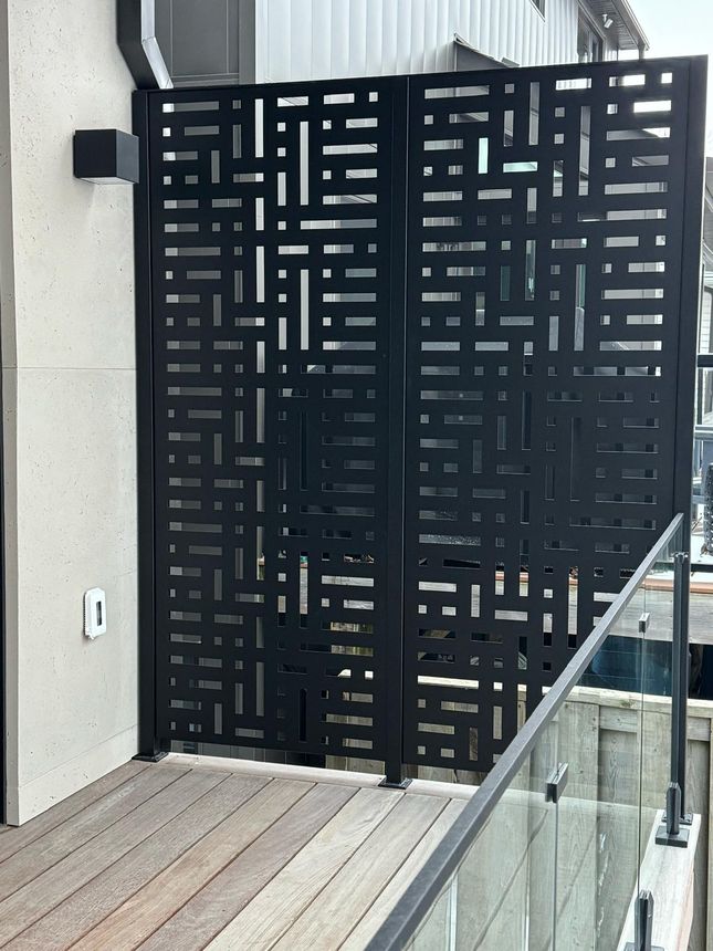 Custom black laser-cut decorative privacy screen panels for a balcony enclosure