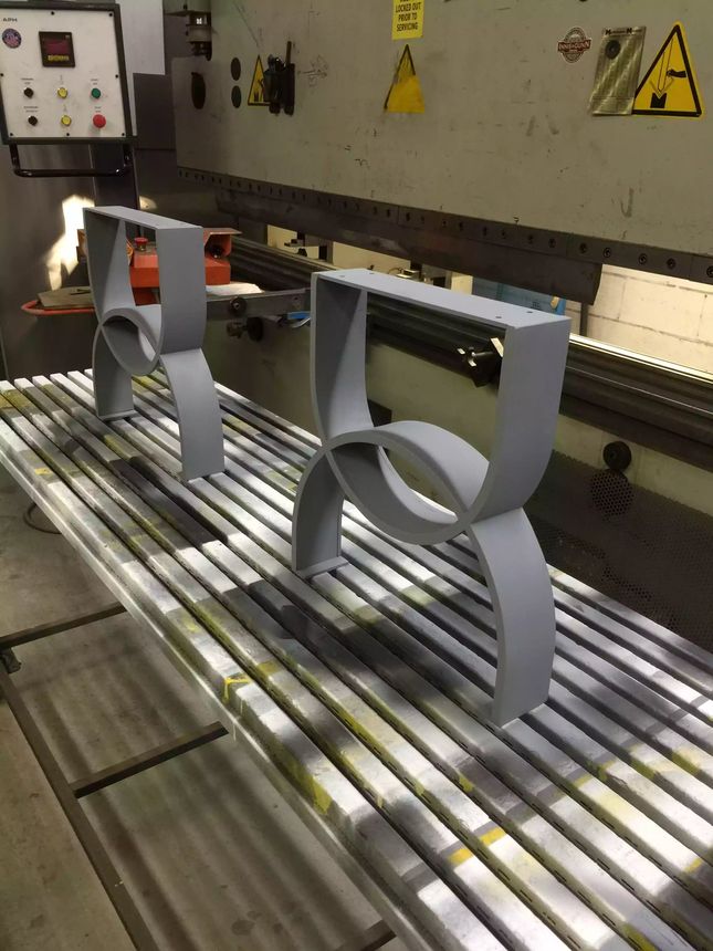 Custom ornamental steel components with smooth flowing curves, formed and finished in-house.