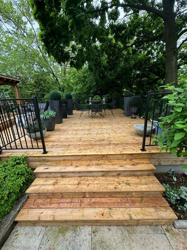 Multi-level deck with custom black metal railing and integrated steps