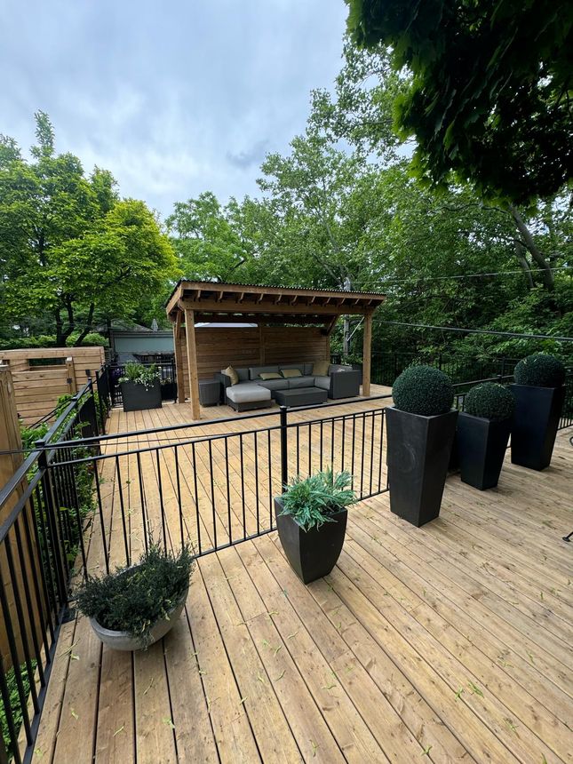 Clean black metal deck railing wrapping a spacious backyard deck