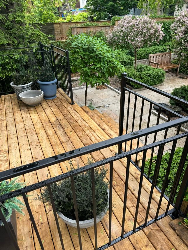 Deck railing in black steel pickets overlooking the garden