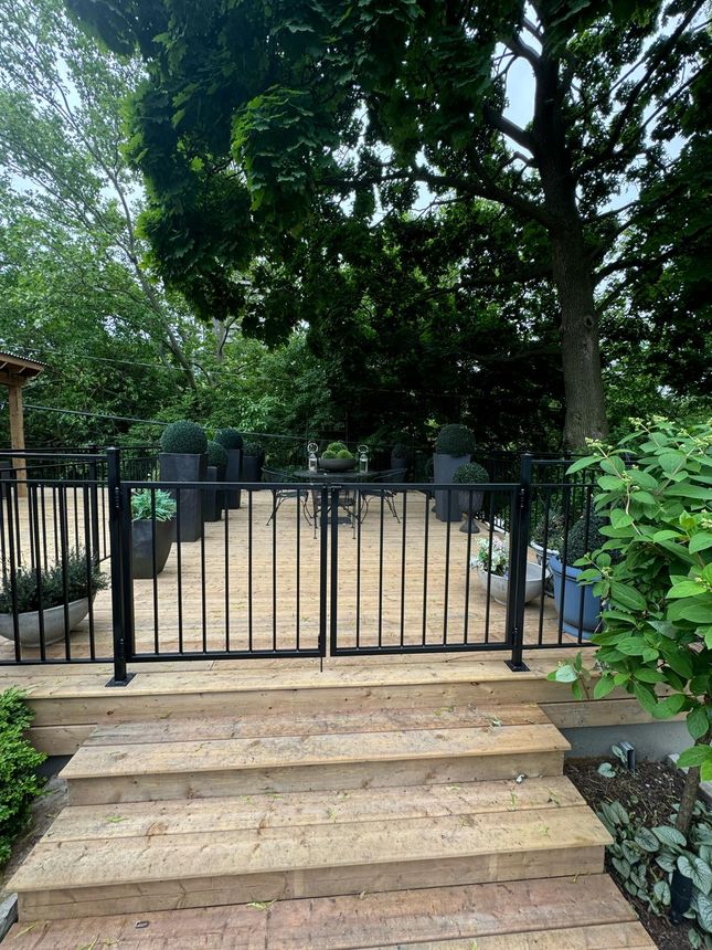 Black metal deck railing with integrated gate at the stair landing