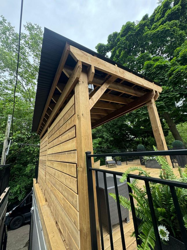 Black aluminum-style deck railing paired with custom cedar woodwork