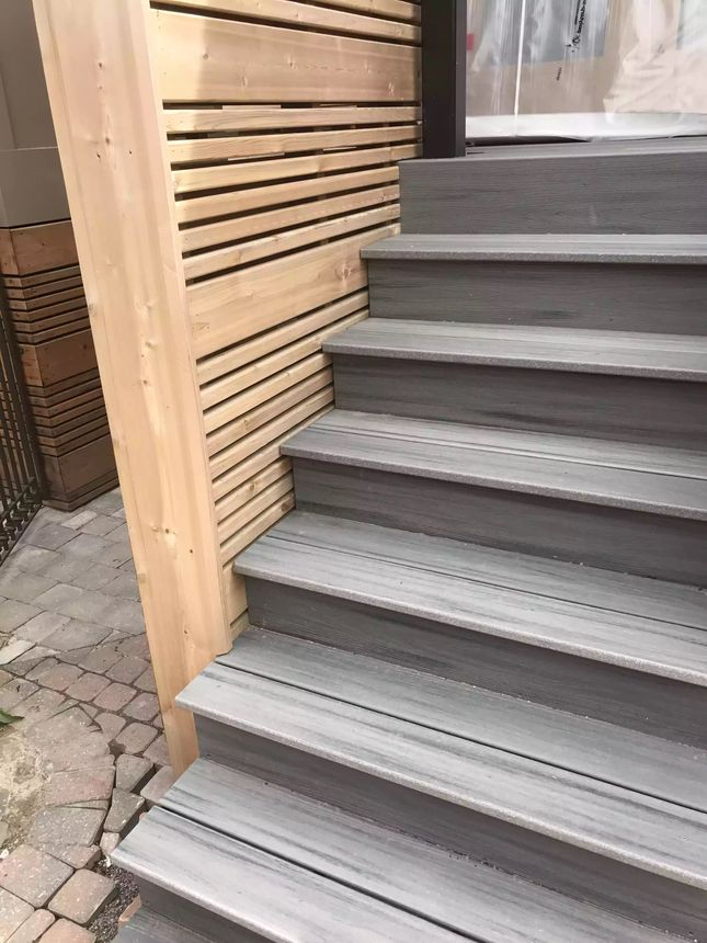 Composite entry steps paired with a horizontal cedar slat privacy screen.