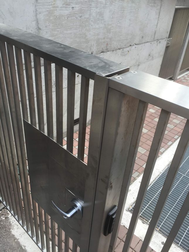 Custom brushed stainless steel slat gate with a clean horizontal-bar design and integrated lever hardware.