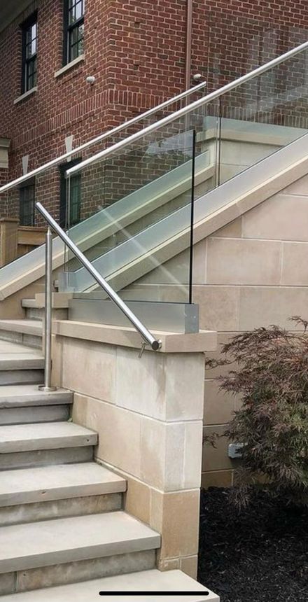 Modern stainless steel and glass railing on exterior stone staircase