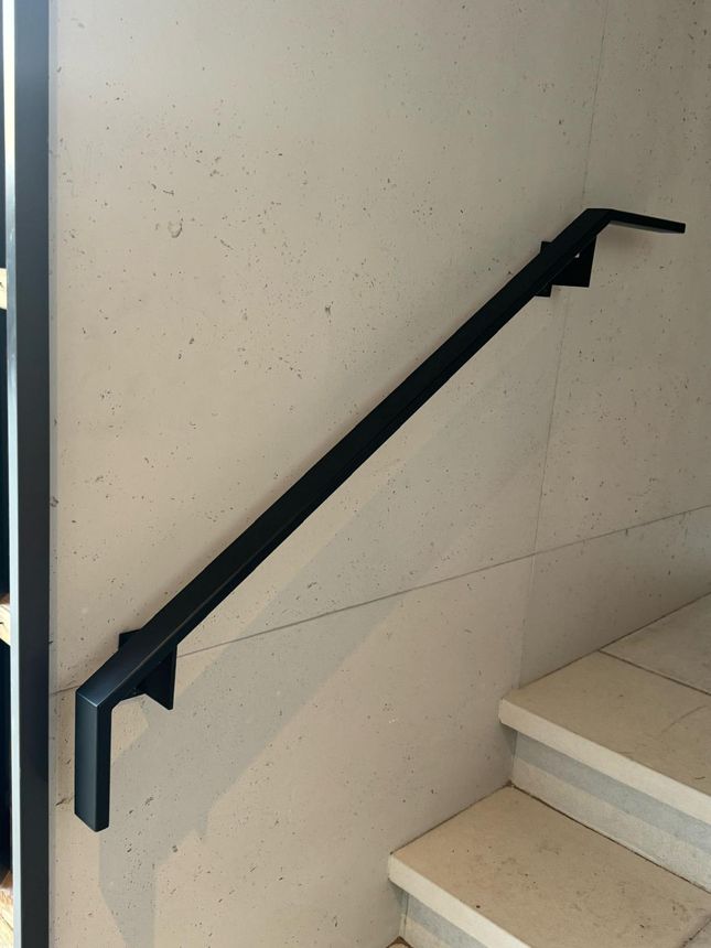 Minimalist matte-black wall-mounted steel handrail