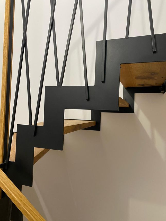 Custom steel mono-stringer staircase with floating oak treads and crisscross picket railing