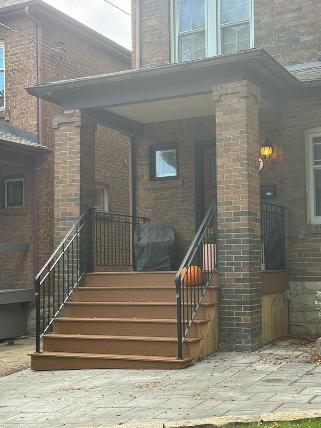 Matching wrought-iron handrails framing a covered front porch entrance