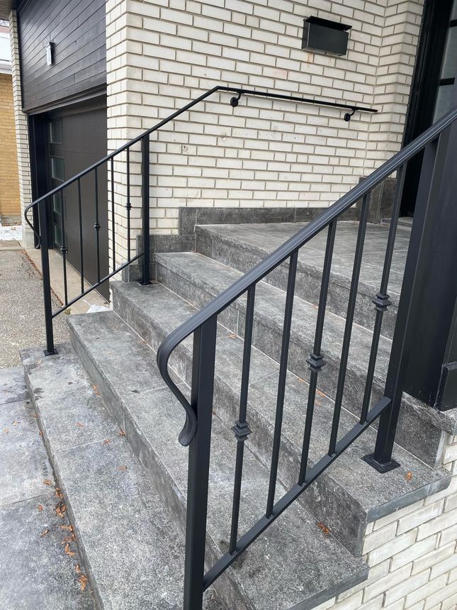 Exterior front-step railing with ornamental pickets and a wall-mounted handrail