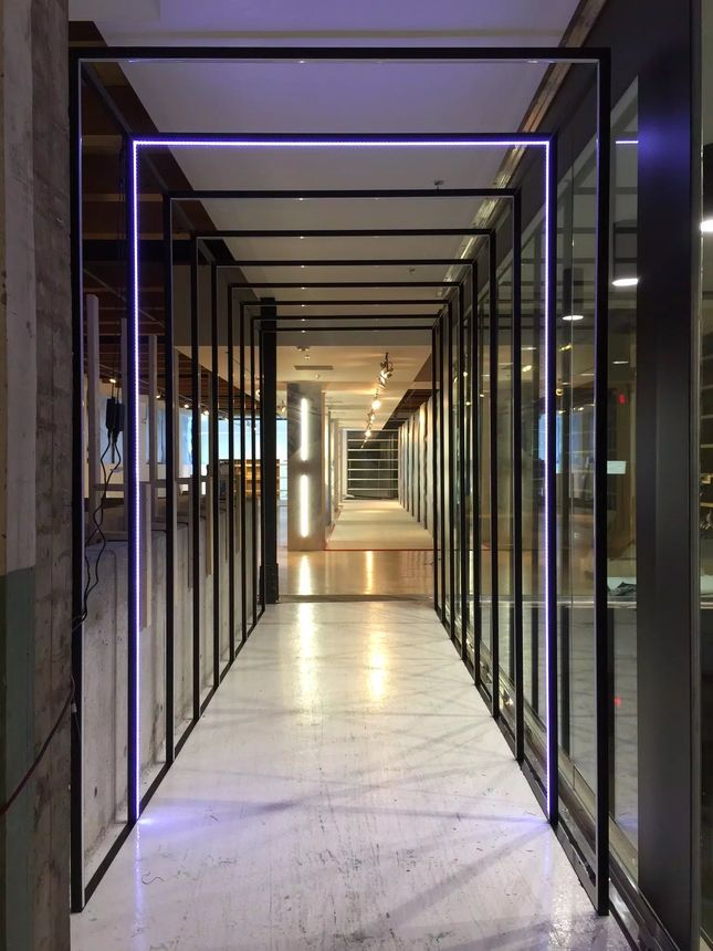 Custom structural steel portal frames with integrated LED lighting, fabricated and installed for a commercial loft interior.