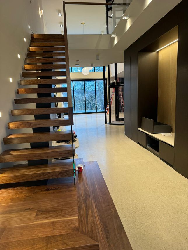 Floating staircase with steel mono-stringer support and glass railing
