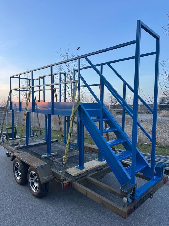 Heavy-duty steel work platform with integrated access staircase